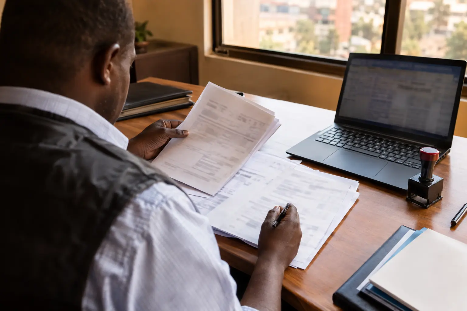 Alibaba shipping to Kenya: clearing agent reviewing import documents at a desk in Nairobi